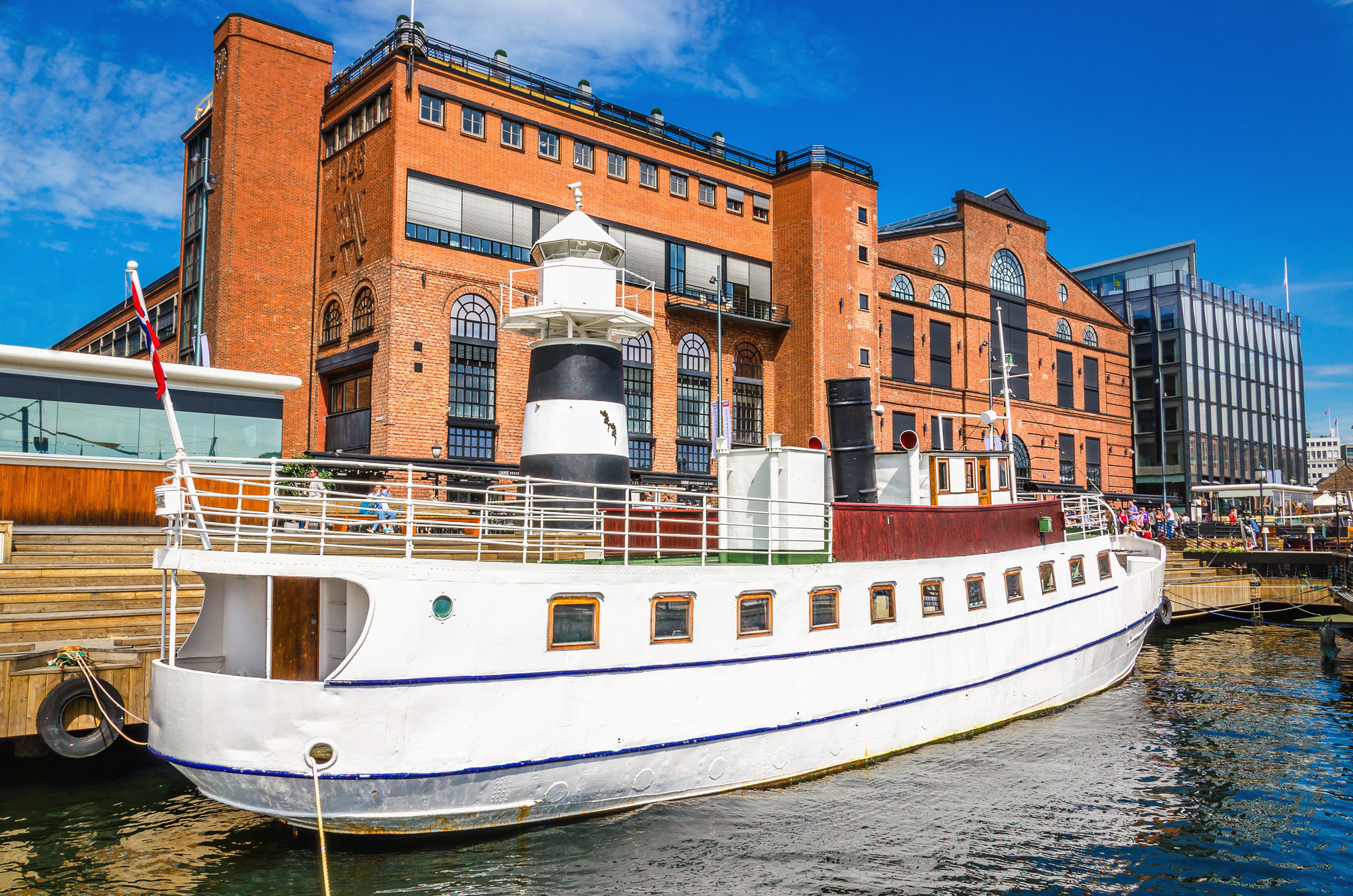 Aker Brygge à Oslo avec un yacht blanc dans le port