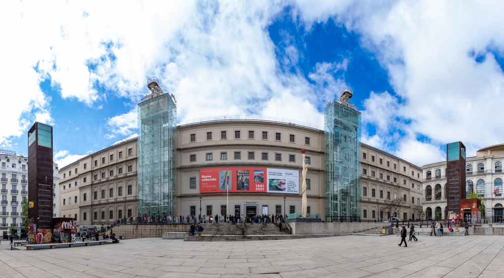 Visiter Madrid : que faire ? 18 lieux à voir et activités 24 La façade principale du musée Reina Sofía à Madrid avec des visiteurs qui font la queue à l’entrée
