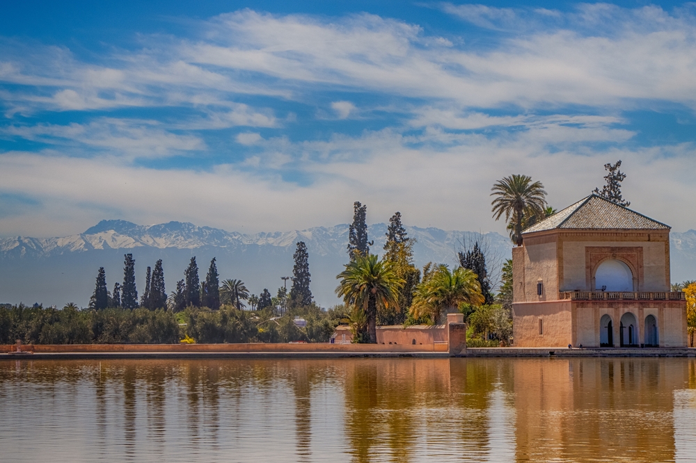 Les jardins de la Ménara à Marrakech avec le pavillon et les montagnes de l’Atlas en arrière-plan