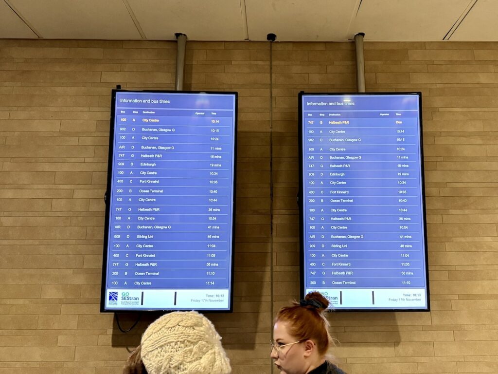 Écran d’information avec les horaires des bus à l’aéroport d’Édimbourg