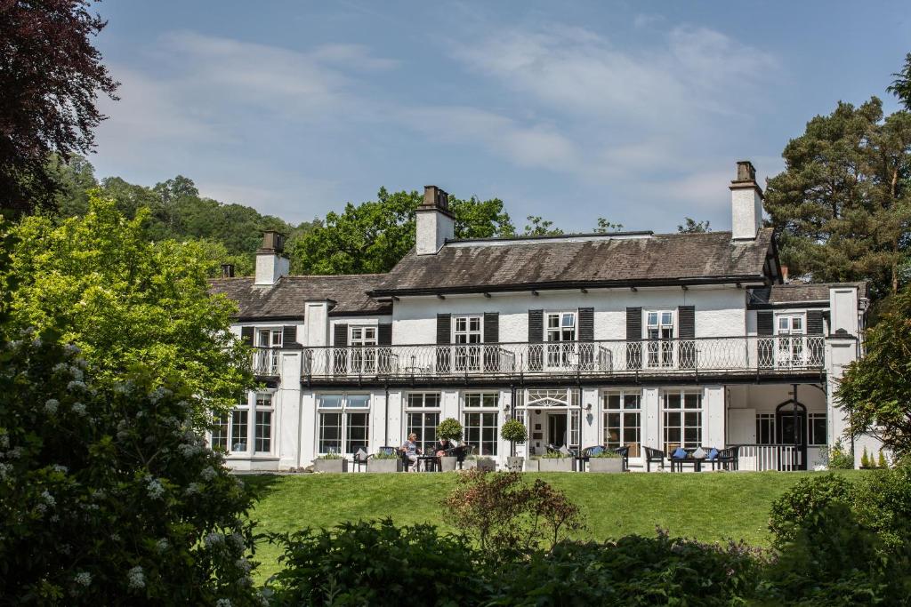 Où dormir dans le Lake District ? Les 5 meilleurs quartiers et hébergements 17 Façade blanche et balcon du Rothay Manor Hotel, encadrés par les arbres de son jardin