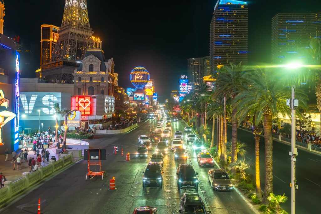 Où dormir à Las Vegas ? Les 5 meilleurs quartiers et hôtels 24 La circulation, des palmiers et des hôtels illuminés le long du Strip de Las Vegas, la nuit
