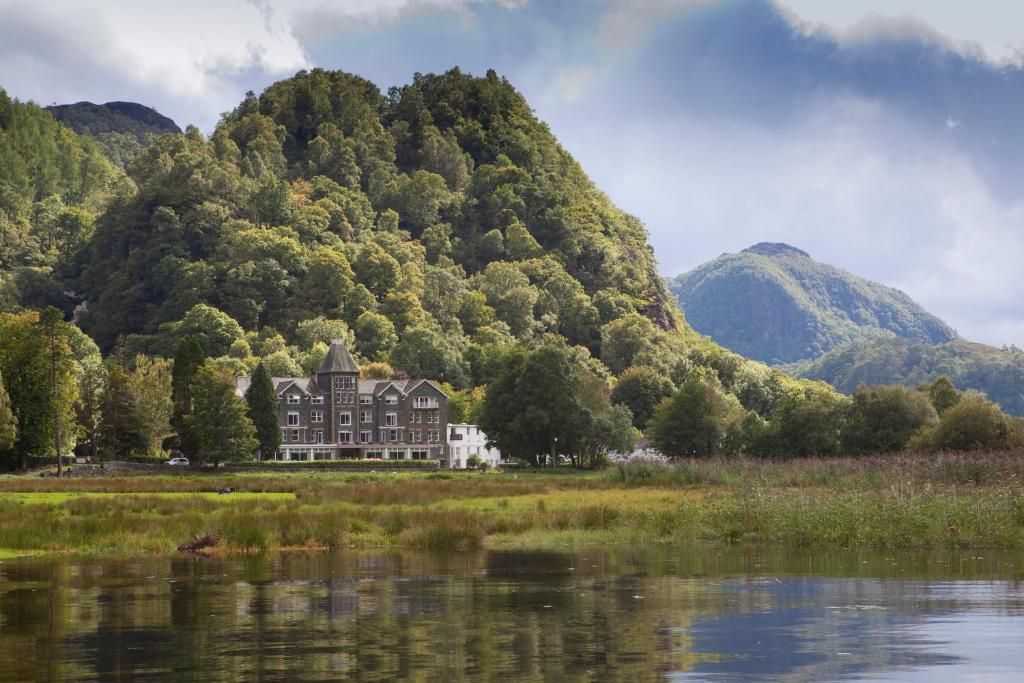 Où dormir dans le Lake District ? Les 5 meilleurs quartiers et hébergements 19 Le Lodore Falls Hotel se reflète dans l’eau au bord de Derwentwater, avec une forêt derrière lui