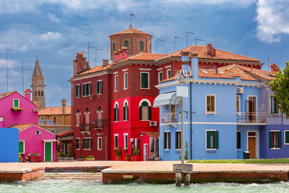 Visiter Venise : que faire ? 18 lieux à voir et activités 36 Des maisons colorées le long d’un canal à Burano avec le clocher en arrière-plan