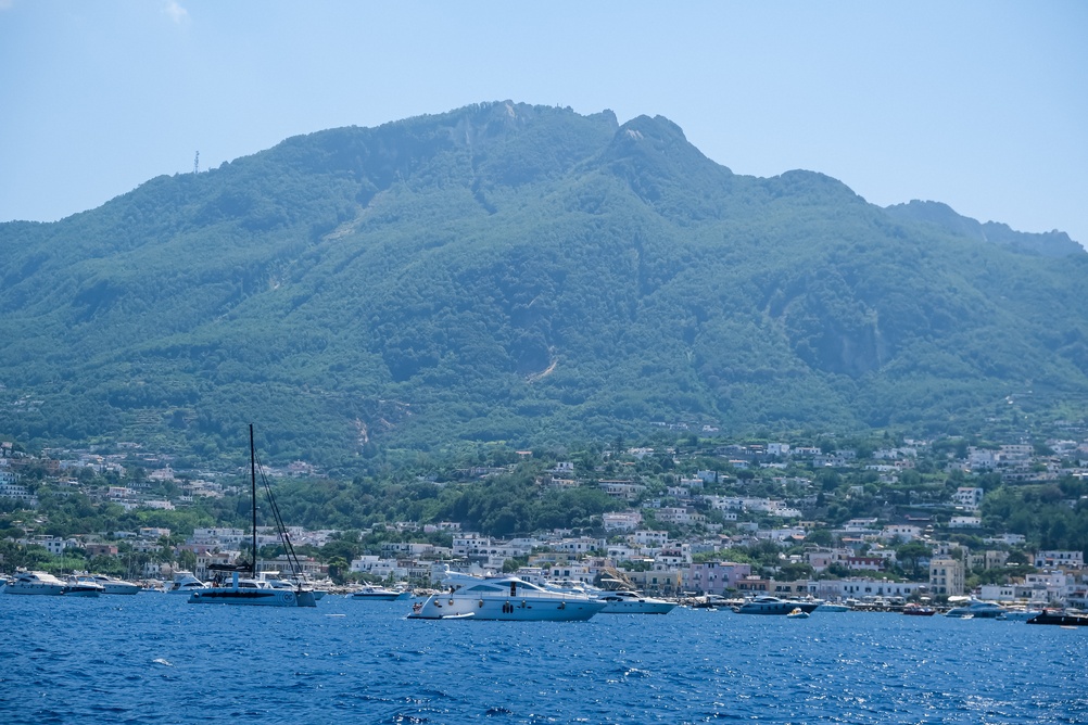 Le mont Epomeo et une ville portuaire d’Ischia avec des bateaux au mouillage au premier plan