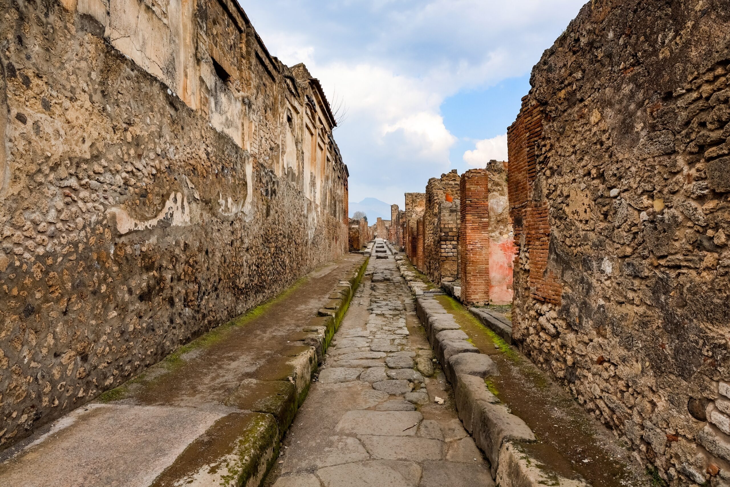 Visiter Naples : que faire ? 17 lieux à voir et activités 32 Une rue romaine de Pompéi avec le Vésuve au fond