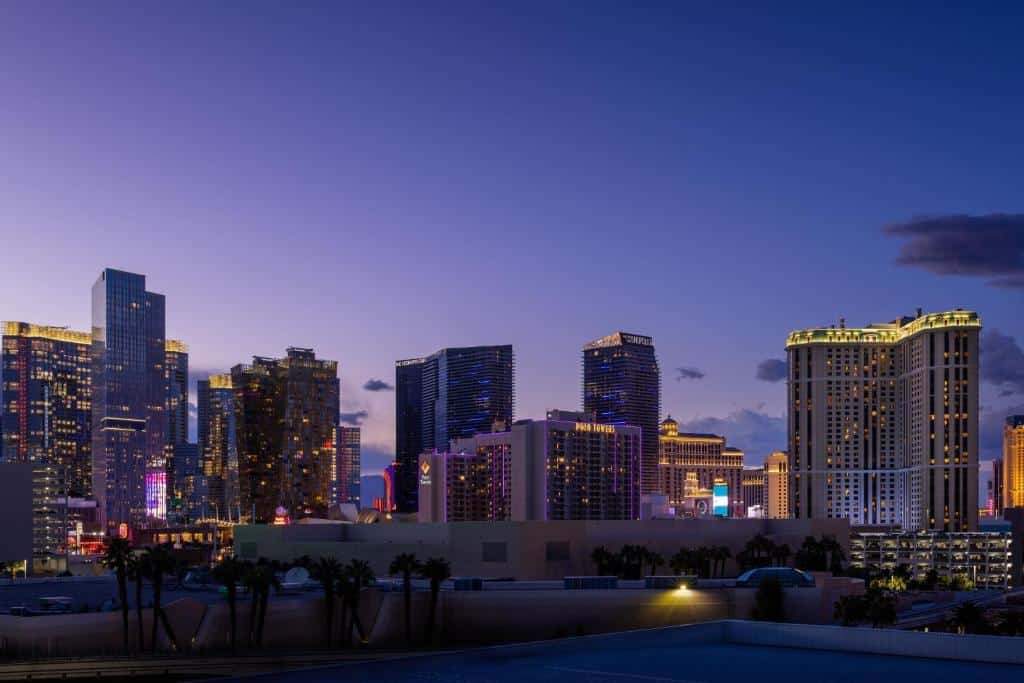 Où dormir à Las Vegas ? Les 5 meilleurs quartiers et hôtels 22 Vue sur les hôtels de Las Vegas au crépuscule, avec un palmier au premier plan